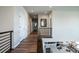 Hallway with hardwood floors, contemporary railing, and view into the open concept kitchen downstairs at 695 Simmental Loop, Castle Rock, CO 80104