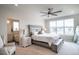 Bright main bedroom with ceiling fan, bench, and luxurious ensuite bathroom with soaking tub at 695 Simmental Loop, Castle Rock, CO 80104