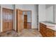 Bathroom with tiled floors, wood cabinets and doors, granite countertop and shelving at 14440 Eagle Vista Dr, Littleton, CO 80127