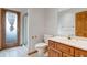 A bathroom features wood cabinets, a standing shower with a curtain, a toilet, and a mirror at 14440 Eagle Vista Dr, Littleton, CO 80127
