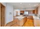Open-concept kitchen featuring a large island with a cooktop, wood cabinets, and stainless appliances at 14440 Eagle Vista Dr, Littleton, CO 80127