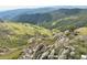 Rocky terrain gives way to a valley filled with green meadow and lush forest at 14440 Eagle Vista Dr, Littleton, CO 80127