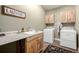 Laundry room with washer, dryer, cabinets, and a utility sink at 42280 Kingsmill Cir, Elizabeth, CO 80107