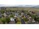 Aerial view of a neighborhood featuring mature trees and lush green landscaping with mountain views at 248 Summit Trl, Broomfield, CO 80020