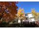 A view of the home's exterior with lush trees in the backyard and a clear blue sky at 248 Summit Trl, Broomfield, CO 80020