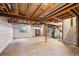 Unfinished basement with exposed wood ceiling, wrapped walls, and a staircase to the upper floors at 248 Summit Trl, Broomfield, CO 80020