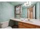 Cozy bathroom features a long countertop, single sink, decorative mirror, and soft green paint at 248 Summit Trl, Broomfield, CO 80020