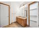 A bathroom featuring a double sink vanity, tiled floors, and a walk-in closet nearby at 248 Summit Trl, Broomfield, CO 80020