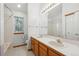 Bathroom featuring double sinks, white cabinets, and a shower with a window at 248 Summit Trl, Broomfield, CO 80020