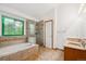Spa-like bathroom boasts a soaking tub, glass shower, and ornate stained glass window at 248 Summit Trl, Broomfield, CO 80020