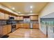 Open kitchen with stainless steel appliances, wood cabinetry, and hardwood floors at 248 Summit Trl, Broomfield, CO 80020