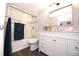 Bathroom with updated vanity, framed mirror, and tiled shower/tub with glass doors at 3111 W Bails Pl, Denver, CO 80219