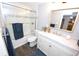 Bathroom with updated vanity, framed mirror, and tiled shower/tub with glass doors at 3111 W Bails Pl, Denver, CO 80219
