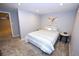 Cozy bedroom with neutral walls, carpeted floors, and side tables with egress window and adjacent bathroom at 3111 W Bails Pl, Denver, CO 80219