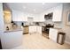 Updated kitchen with stainless steel appliances, white cabinetry, and light countertops at 3111 W Bails Pl, Denver, CO 80219