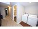 Laundry room next to an updated bathroom; view from adjacent hallway at 3111 W Bails Pl, Denver, CO 80219