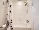 Clean bathroom features a white tub, shower with a floral curtain, and chrome fixtures at 6379 S Jasmine Way, Centennial, CO 80111