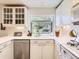 Well-lit kitchen featuring a garden window, white cabinets and stainless steel dishwasher at 6379 S Jasmine Way, Centennial, CO 80111