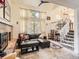 Cozy living room with a brick fireplace, a comfortable leather sofa, and access to the staircase at 6379 S Jasmine Way, Centennial, CO 80111
