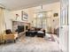 Bright living room featuring a brick fireplace, plush carpet, and large windows with natural light at 6379 S Jasmine Way, Centennial, CO 80111