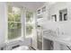 All-white bathroom featuring a toilet, pedestal sink, cabinet, and a large window with backyard views at 368 S Humboldt St, Denver, CO 80209