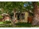 Charming home exterior with mature trees, lush lawn, and a quaint covered porch at 368 S Humboldt St, Denver, CO 80209