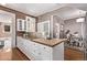 Kitchen featuring white cabinets, hardwood floors, a brick wall, and access to dining area at 368 S Humboldt St, Denver, CO 80209