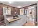 Charming kitchen with exposed brick, an island, white cabinets, and modern appliances at 368 S Humboldt St, Denver, CO 80209