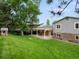 Expansive backyard with a covered patio and lush green lawn at 13762 W 67Th Pl, Arvada, CO 80004