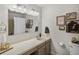 Bright bathroom featuring a large mirror, vanity with storage, and neutral decor at 13762 W 67Th Pl, Arvada, CO 80004