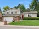 Two-story home featuring a red front door, attached two car garage, and a well-manicured front lawn at 13762 W 67Th Pl, Arvada, CO 80004