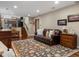 Cozy living room with a leather sofa, decorative rug, and a staircase leading to the upper level at 13762 W 67Th Pl, Arvada, CO 80004