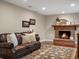 Comfortable living room with a brick fireplace, leather sofa, and stylish decor at 13762 W 67Th Pl, Arvada, CO 80004