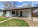 Backyard exterior with covered porch, green grass, and a walkway at 6913 Teller Ct, Arvada, CO 80003