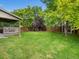 Manicured backyard features lush lawn and mature trees, perfect for relaxation and entertainment at 23222 E Orchard Pl, Aurora, CO 80015