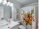 Bathroom featuring a white vanity, floral shower curtain, and artwork on the walls at 23222 E Orchard Pl, Aurora, CO 80015