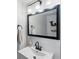 Close-up of bathroom vanity with white sink, dark hardware, and modern mirror and lighting at 23222 E Orchard Pl, Aurora, CO 80015