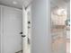 Hallway view of a small bathroom with open door and white paint at 23222 E Orchard Pl, Aurora, CO 80015