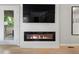 Modern fireplace with glass front and tv, along with french doors to the outside at 23222 E Orchard Pl, Aurora, CO 80015