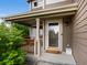 Covered front porch featuring wood columns, neutral siding, and storm door with a full view glass panel at 23222 E Orchard Pl, Aurora, CO 80015