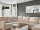 Comfortable living room with a large sectional, dark accent wall, and bright natural light from the windows at 23222 E Orchard Pl, Aurora, CO 80015