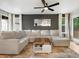 Spacious living room featuring a plush sectional, modern ceiling fan, light wood flooring, and natural light at 23222 E Orchard Pl, Aurora, CO 80015