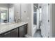 Modern bathroom with double vanity, stone countertops, a soaking tub/shower combo, and large mirror at 2592 S Norse Ct, Lakewood, CO 80228
