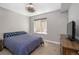 Bedroom with plush carpeting, queen size bed, large window, and wood dresser at 2592 S Norse Ct, Lakewood, CO 80228