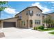 Inviting two-story stucco home featuring an attached garage, well-maintained landscaping and a concrete driveway at 2592 S Norse Ct, Lakewood, CO 80228