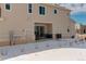 Inviting backyard featuring a patio with black railing, sliding glass doors, and a small door, set against snowy ground at 24501 E 41St Ave, Aurora, CO 80019