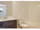 Bright bathroom featuring a toilet, shower over tub, and a vanity with a light countertop and dark cabinet at 24501 E 41St Ave, Aurora, CO 80019