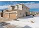 Exterior view of home features a two-car garage, siding, and a snow-covered lawn at 24501 E 41St Ave, Aurora, CO 80019