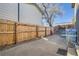 A fenced backyard features a concrete patio and a large tree providing ample shade with a playhouse on the patio at 4783 S Taft St, Morrison, CO 80465