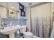 Bathroom featuring a pedestal sink, toilet, and a shower with patterned curtain at 4783 S Taft St, Morrison, CO 80465